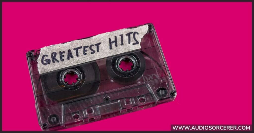 A cassette tape with a piece of masking tape on it, with "greatest hits" written in black Sharpe.
