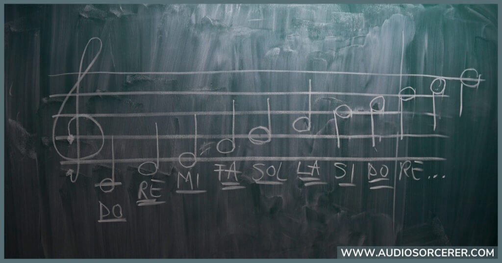 Musical scale written out on a chalk board.